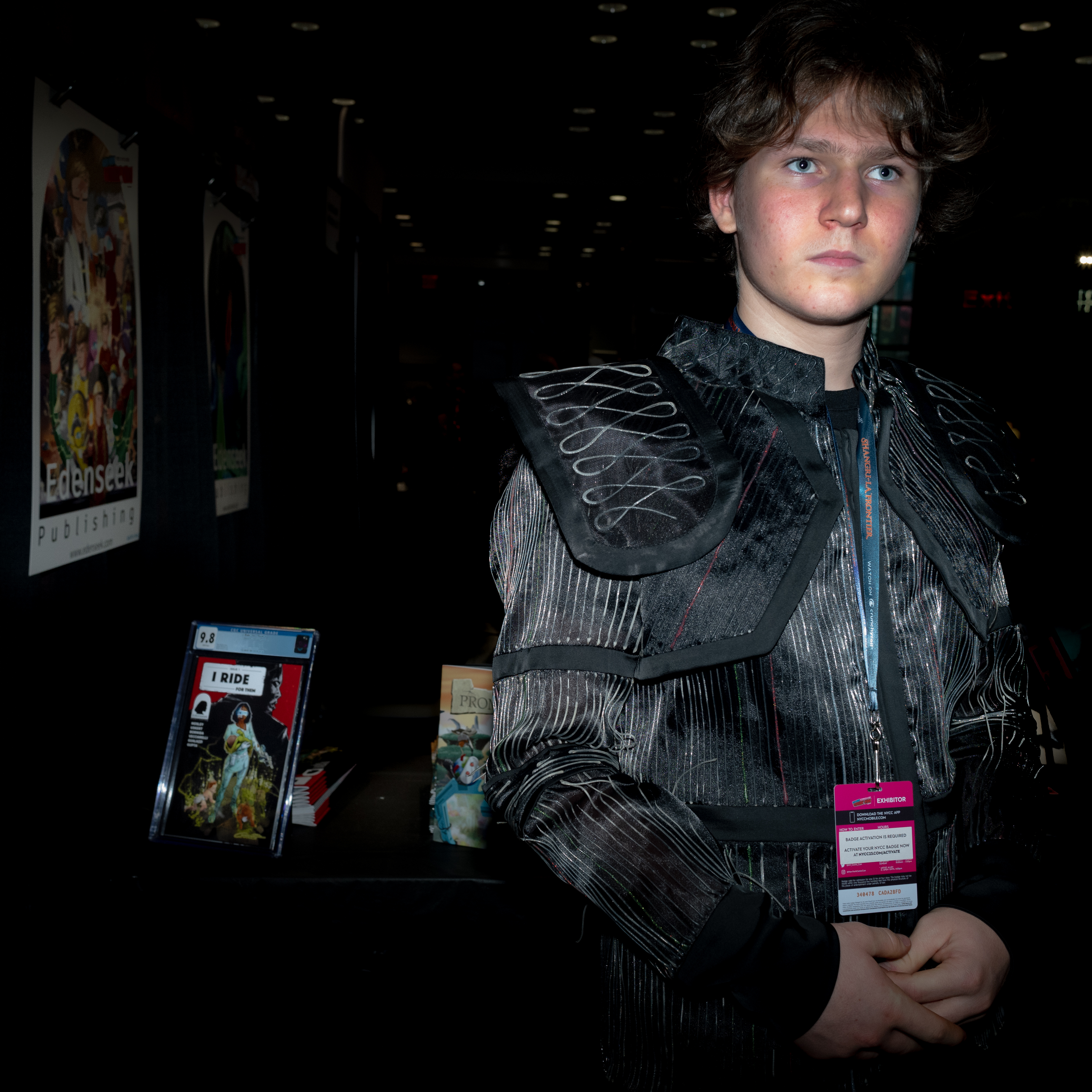Standing in costume at the Edenseek Publishing booth at New York Comic Con, with graded copies of I Ride For Them and Promises on the table