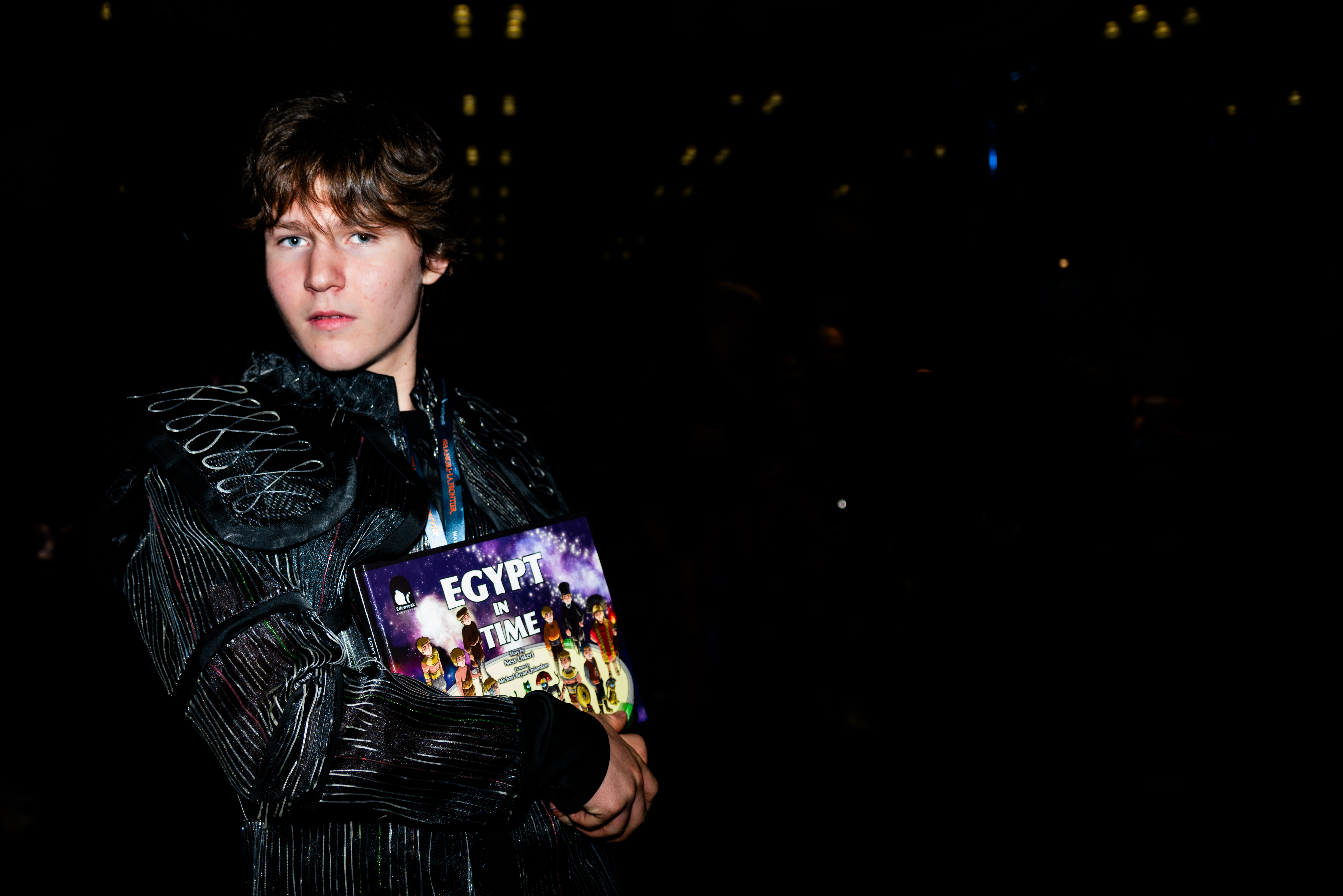 Ness Uskert in costume at New York Comic Con, holding a copy of the picture book Egypt in Time
